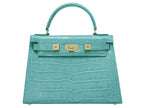 A large turquoise , ‘croc’ print Italian calf leather handbag with top handle, detachable strap and gold plated hardware.