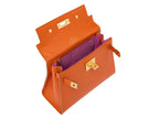 Inside view of an orange luxury handbag with a top handle and gold-plated hardware, made of Italian calf leather featuring bright pink suede leather interior.