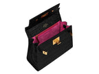 Black handbag with pink interior and gold hardware on a white background