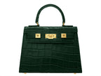 Green ‘croc’ print handbag with gold hardware on a white background