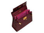 Inside view of a burgundy wine coloured 'Croc' print Italian calf leather handbag with gold plated hardware, a top handle and a detachable strap featuring bright pink suede interior.