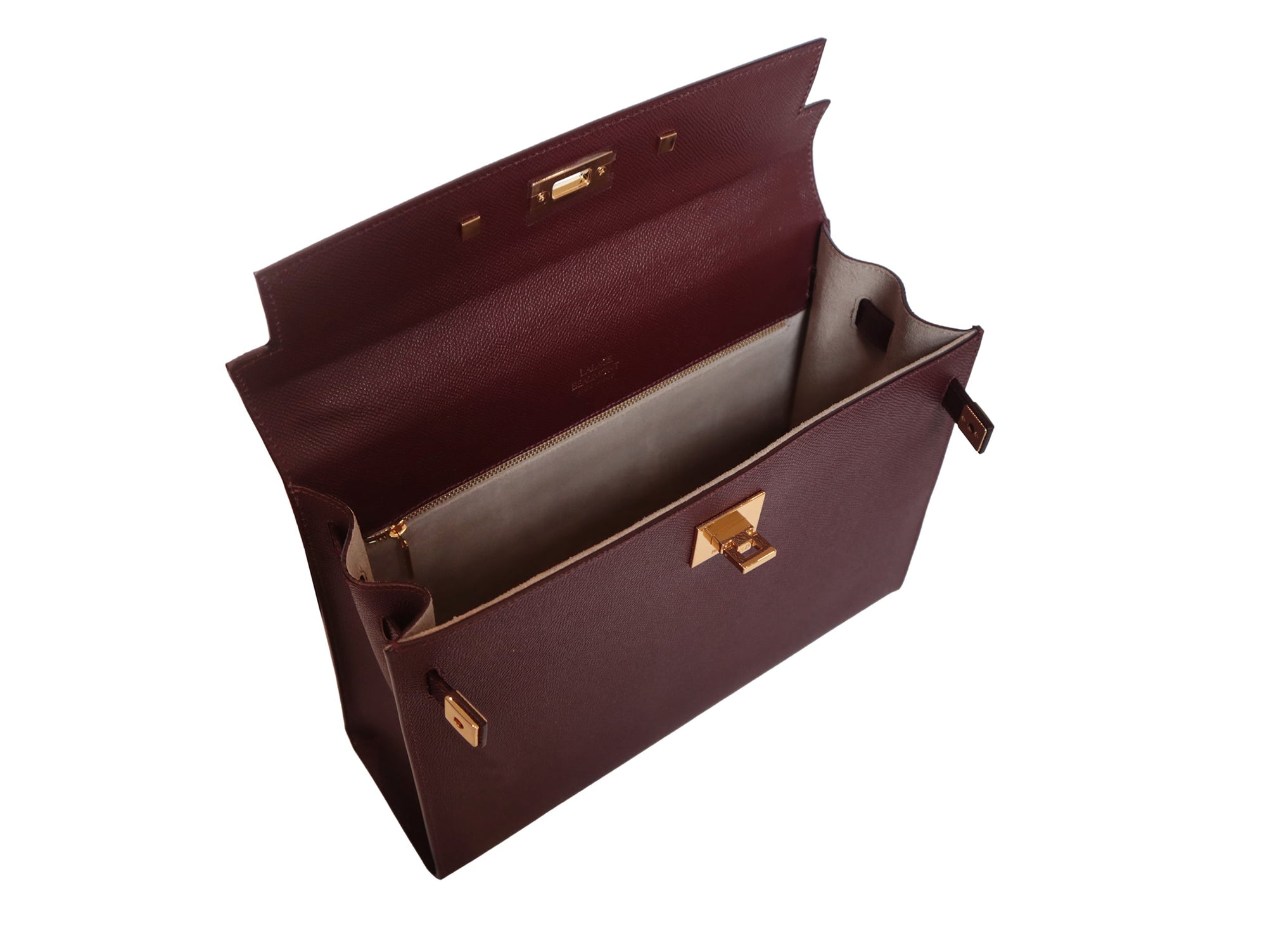 Inside of a large taupe colored Italian calf leather handbag with pebble print texture, gold plated hardware, and a top handle with a detachable strap.