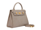 A stone-colored, croc print Italian calf leather handbag with a top handle, detachable strap, and gold plated hardware.