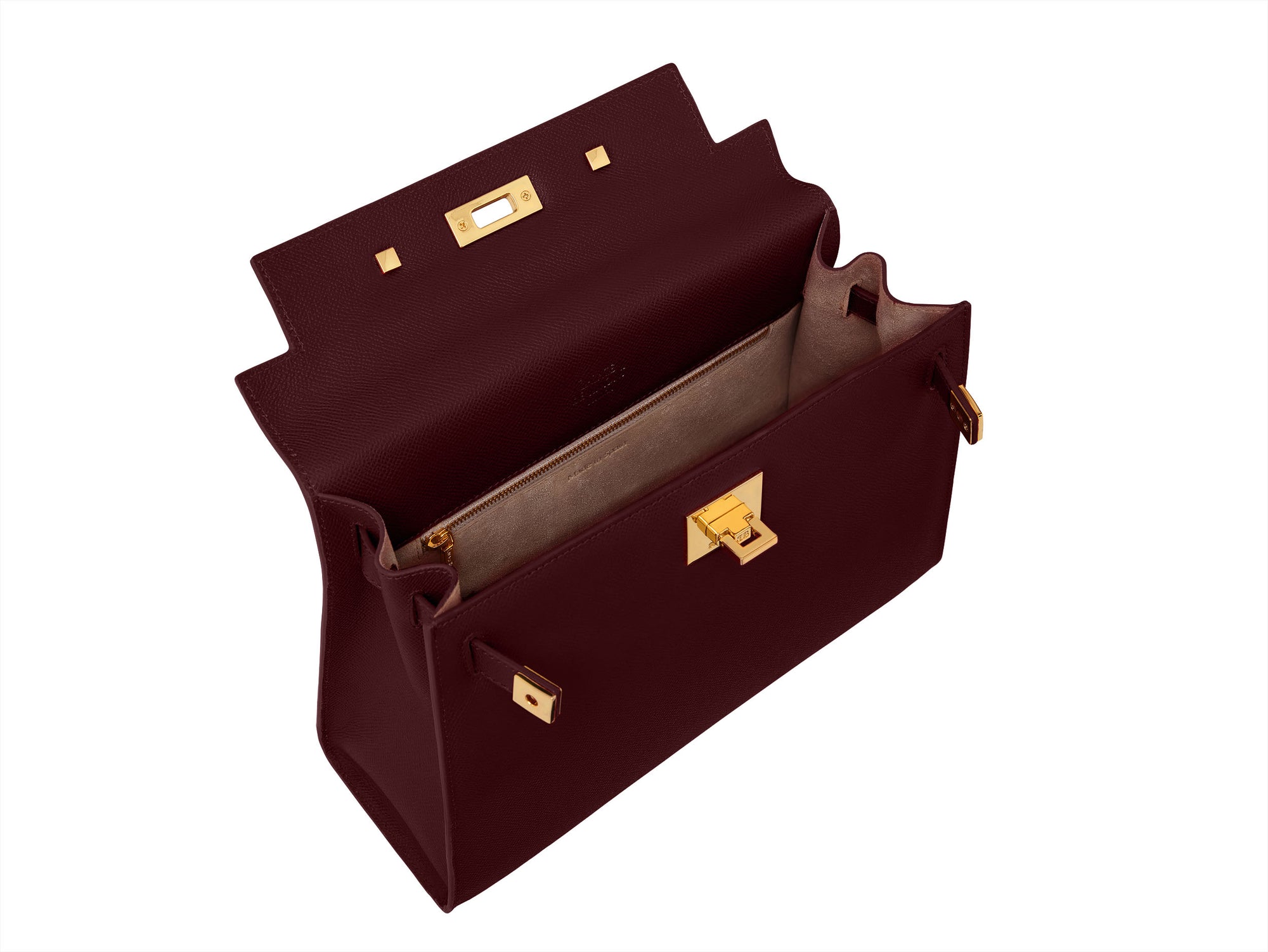Inside of a wine-colored, pebble print Italian calf leather handbag with gold plated hardware, top handle and detachable strap in a structured design.