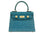 Blue textured ‘lizard’ print Italian leather handbag with gold hardware on a white background